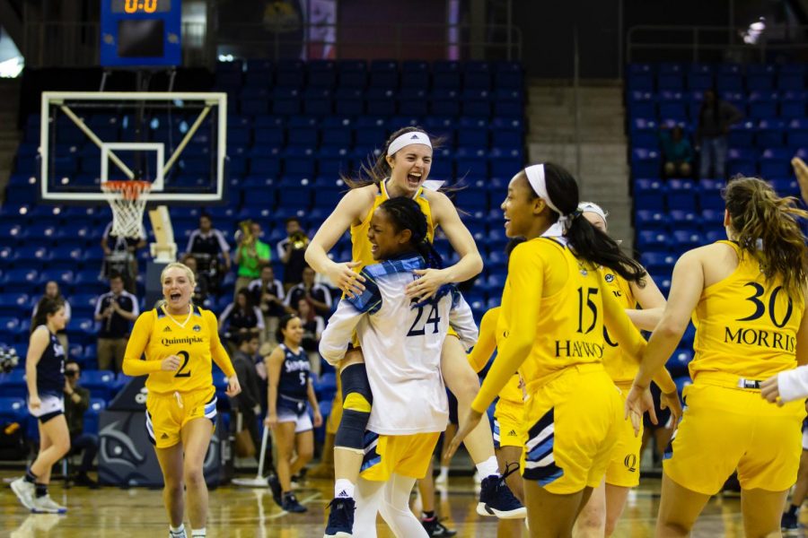 Sophomore guard Mackenzie DeWees leaps into sophomore guard Amani Frees arms following the conclusion of the game.