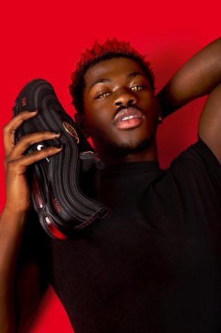 Lil Nas X poses with his Satan shoes custom-made by art collective MSCHF, who Nike has given a restraining order to.