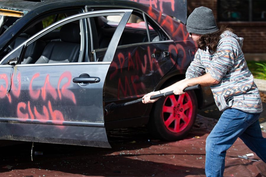 Students relieve their stress at the Car Smash charity event for the Breast Cancer Research Foundation.