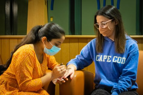 Isabella Prosper, a junior chemistry major, gets henna done on her hand. Henna is a plant-based dye traditionally used
in celebrations in South Asian countries.
