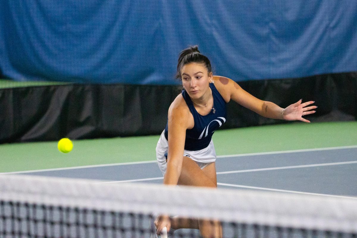 Sophomore Nikole Lisovyy backhands the ball during a match against Stonehill on Feb. 10.