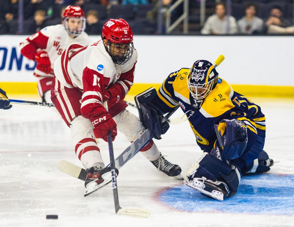 Senior goaltender Vinny Duplessis stops a scoring chance from Wisconsin sophomore forward Simon Tassy on March 29.