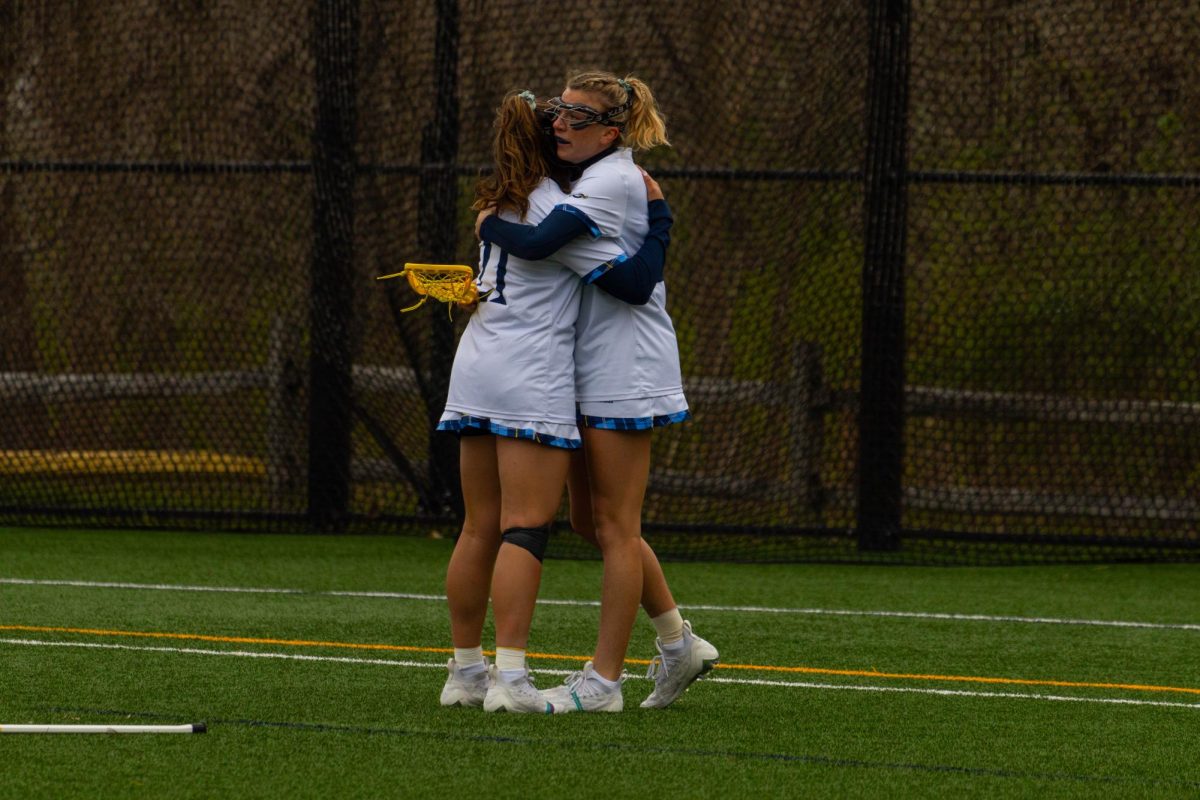 Junior midfielder EllaGrace Delmond and junior attack Abby Wise hug after the Bobcats score a goal during a game against Iona on April 13, 2024