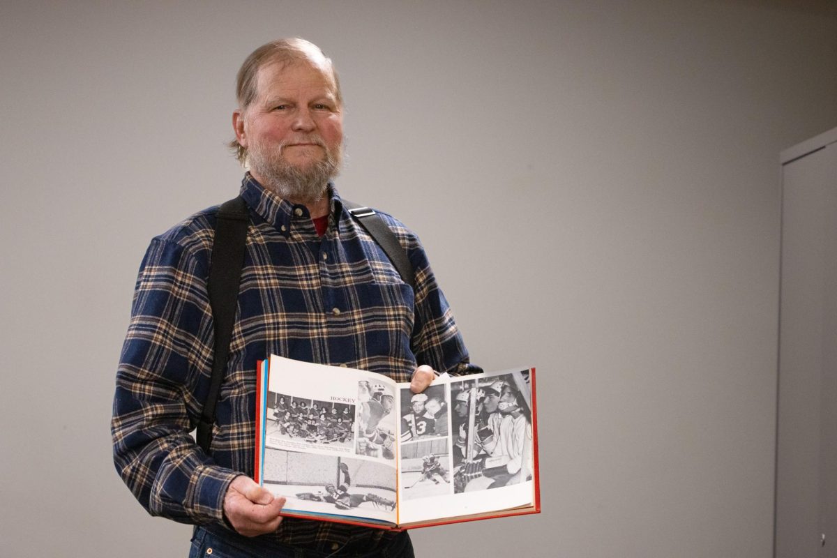 Former Quinnipiac goaltender Kent Allyn displays with a yearbook of the men's club hockey team in one of its first seasons.