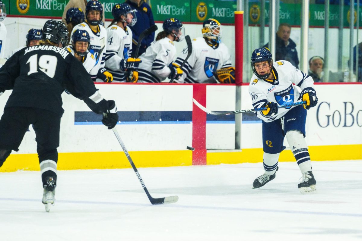 Shay Maloney dumps the puck into the offensive zone in a game against Providence on Dec. 10, 2022.