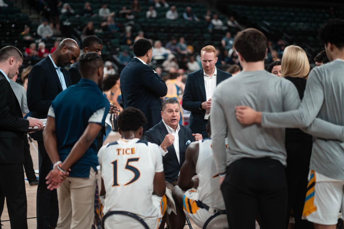 Head coach Tom Pecora huddles with his team during a timeout in a 76-52 win against Canisius in the MAAC quarterfinals on March 13.