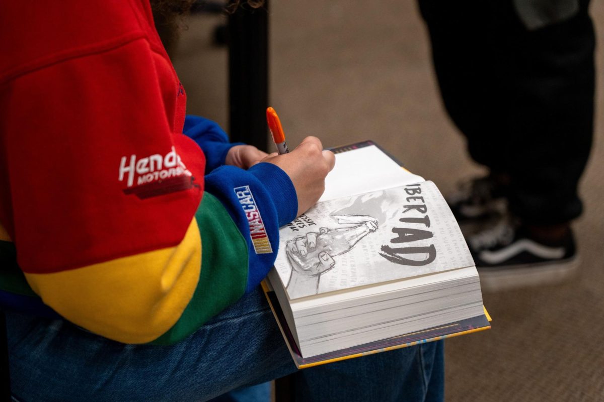 Professor Bessie Flores Zaldivar signs her newly published book 'Libertad.'