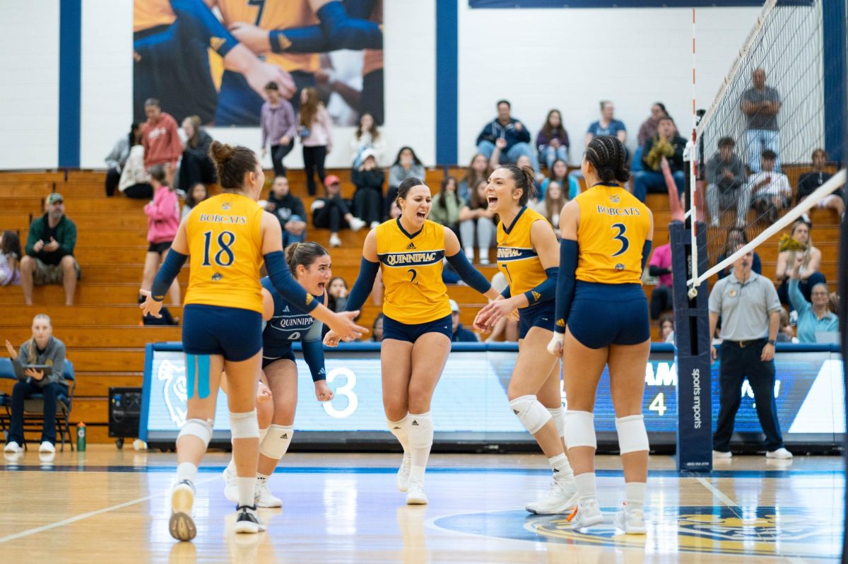 Quinnipiac volleyball celebrates a point in a five-set loss against Saint Peter's on Sept. 29.