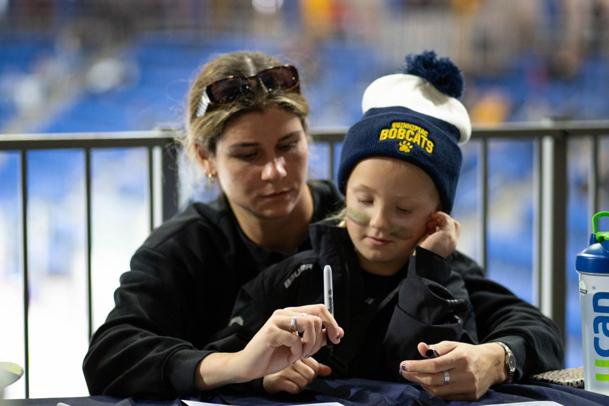 Zoe Boyd ‘23 sits with a fan at the signing booth.