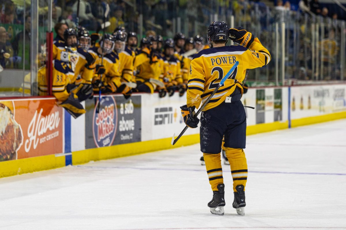 Quinnipiac junior forward Alex Power salutes the bench after scoring in a game against Northeastern on Oct. 6.