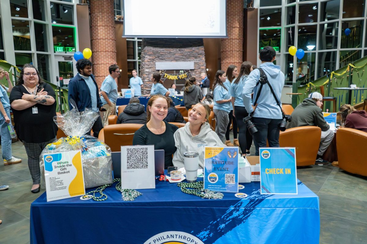 Senior political science major Charley Durst (left) and senior health sciences major Amylia Angér (right) welcome attendees.