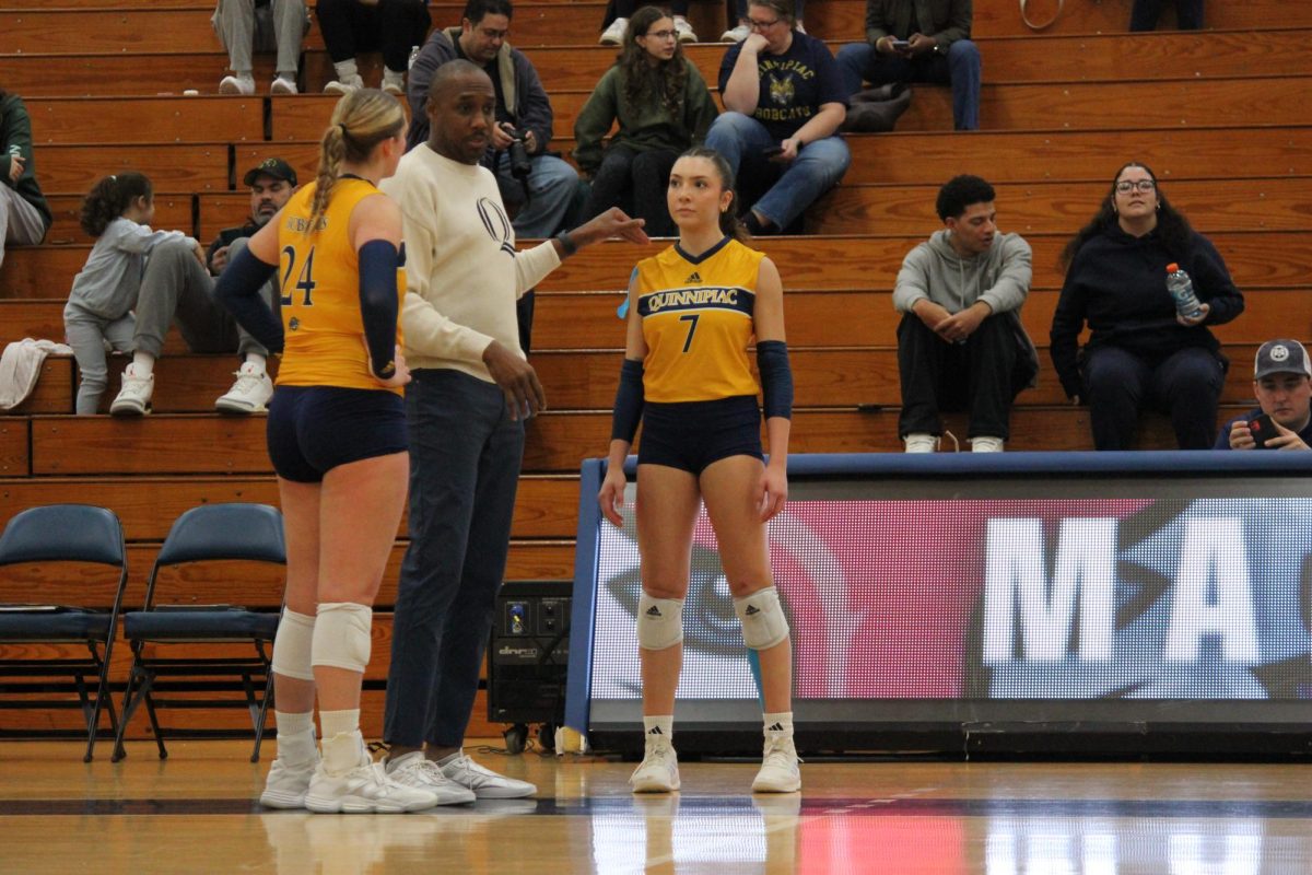 Junior outside hitter Yagmur Gunes and junior middle blocker Bailey Brashear listen to head coach Kyle Robinson's advice during the game. 