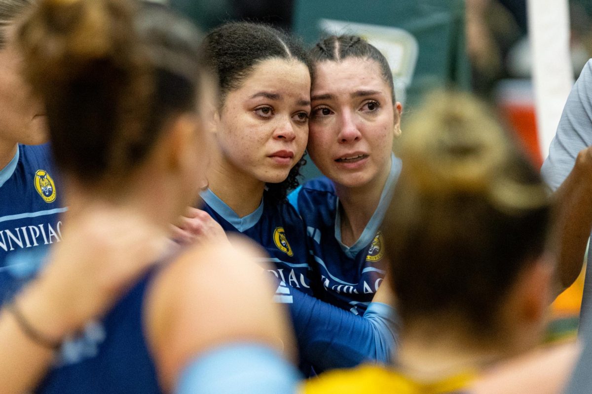 Senior opposite Alexandra Tennon (left) and junior outside hitter Yagmur Gunes hug among the team after their 3-1 loss to Fairfield in the MAAC finals on Nov. 24, 2024. 