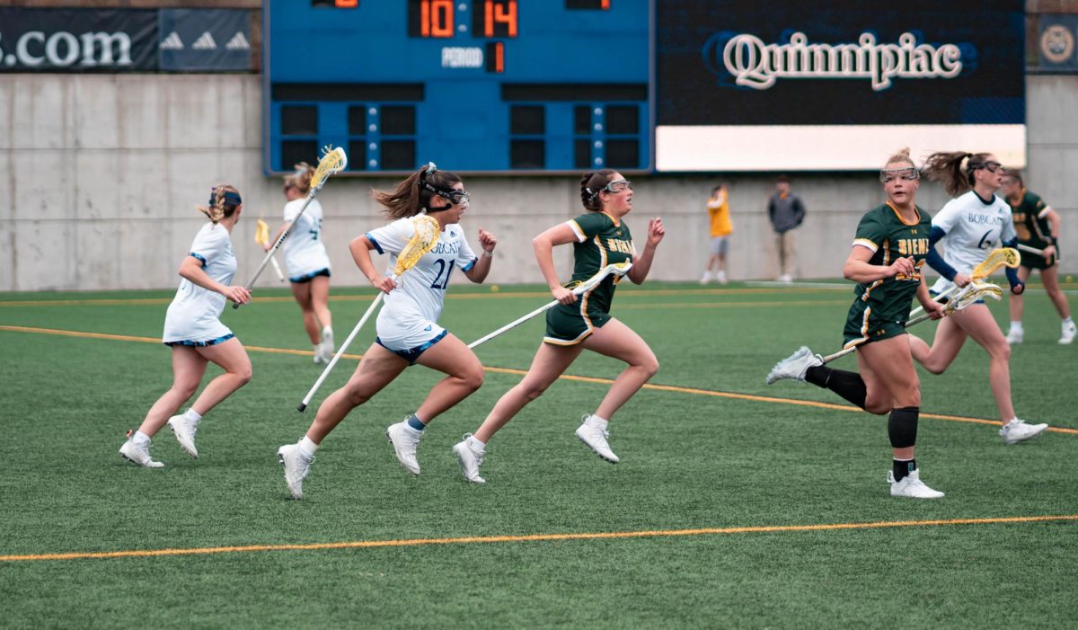 Senior midfielder EllaGrace Delmond runs in a 15-12 loss against Siena on April 17, 2024.