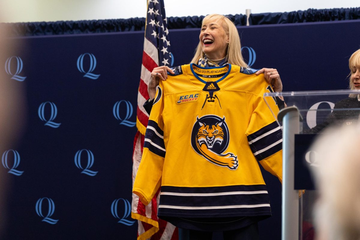 Marie Hardin poses with Quinnipiac's women's ice hockey jersey with No. 10 on its back. 