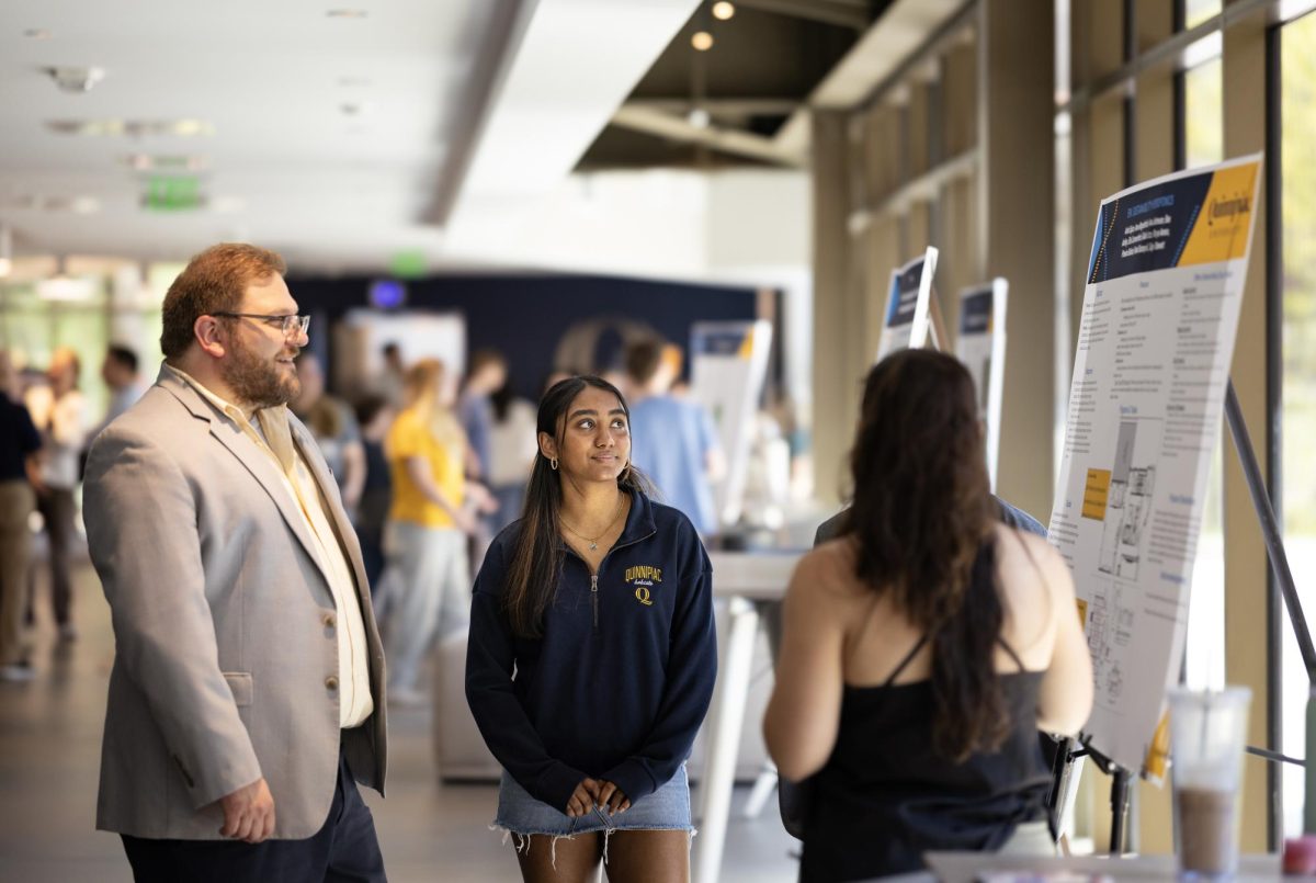 First-year biomedical sciences major Anita Sajan, presents her project to Nicholas Nicholson, professor of nursing, faculty director for the residential experience and first year seminar program director (Photo courtesy of Autumn Driscoll/Quinnipiac University). 