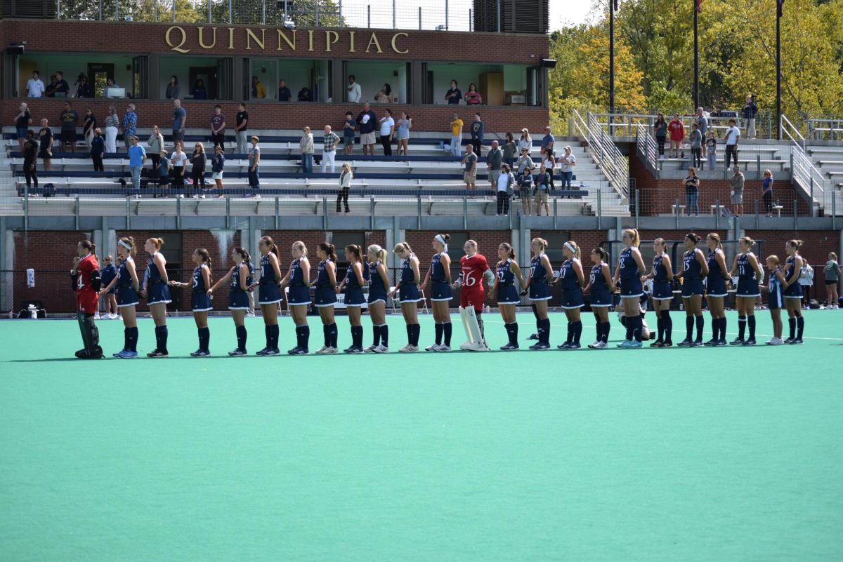 Quinnipiac field hockey holds hands during the National Anthem, before taking on Liberty on Sept. 19.