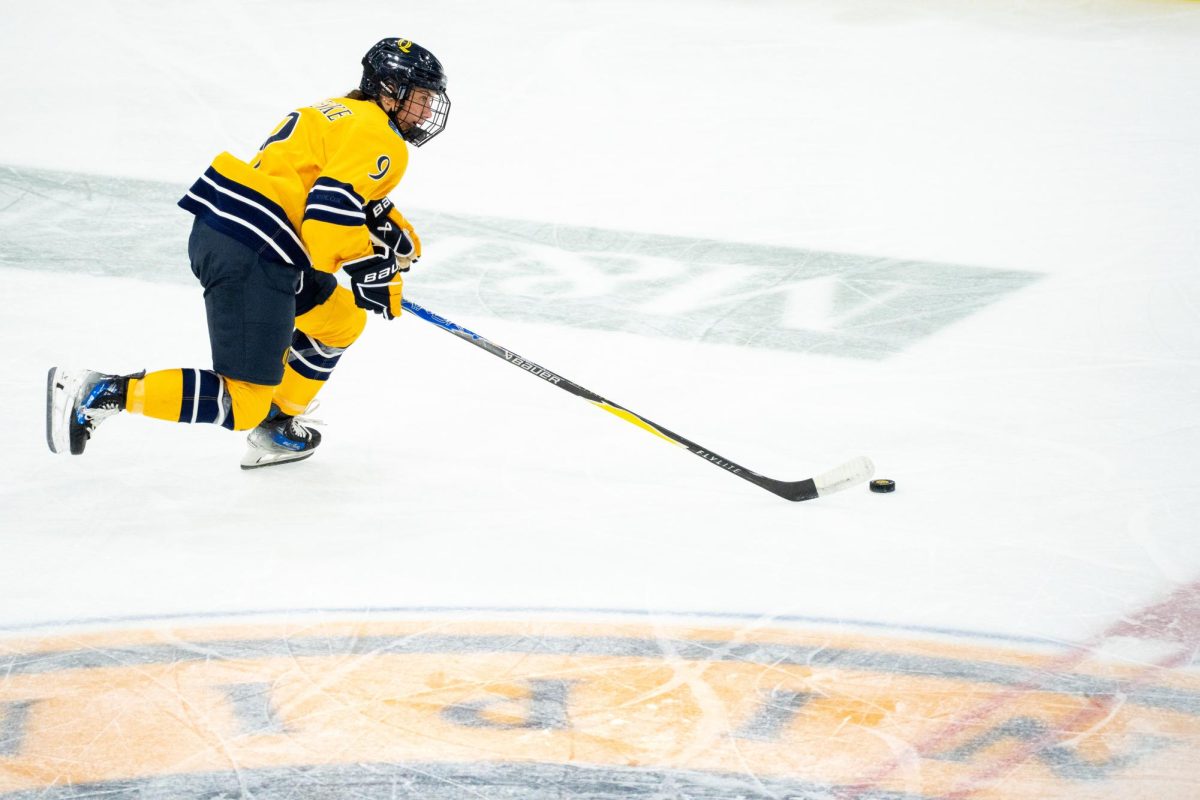 Sophomore forward Taylor Brueske skates down ice against Maine on Sept. 26.