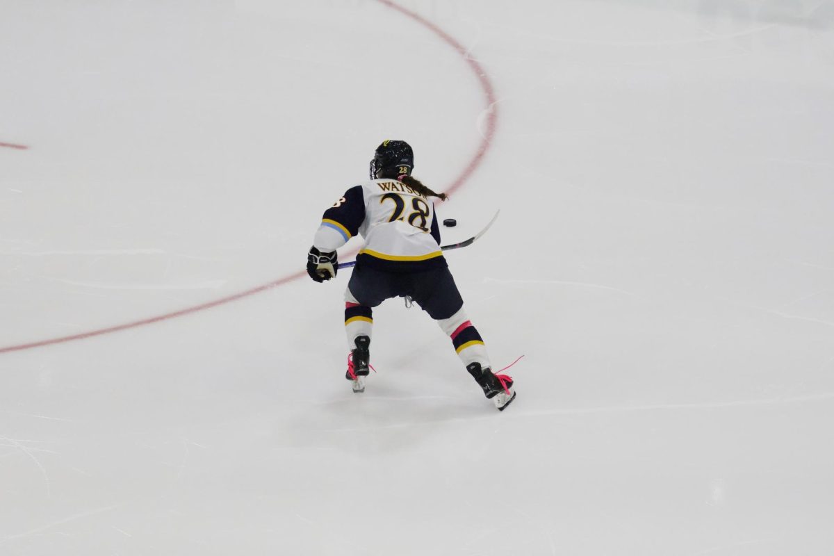 Sophomore defenseman Makayla Watson skates for puck against Providence on Oct. 4.